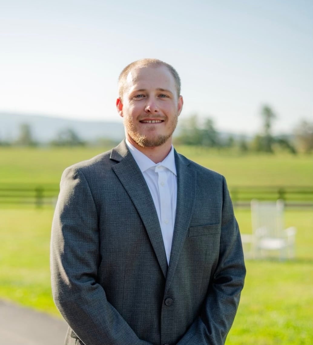 Blaze O'Saben smiling in front of a teal gradient backdrop
